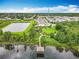 An aerial view showing the neighborhood park with a pond, a pier, and surrounding homes on a sunny day at 6947 Cucamelon Ct, Windermere, FL 34786