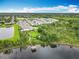 Aerial view of a community showcasing a park with pier access to a pond and well-maintained homes at 6947 Cucamelon Ct, Windermere, FL 34786