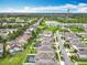 Expansive aerial view showing neighborhood, a shimmering lake, and manicured green spaces and recreational areas at 6947 Cucamelon Ct, Windermere, FL 34786