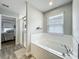 Bright bathroom features a soaking tub, glass shower, and views into the main bedroom at 6947 Cucamelon Ct, Windermere, FL 34786