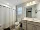 Bathroom with shower, white vanity, toilet, and wood-look tile flooring at 6947 Cucamelon Ct, Windermere, FL 34786