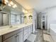 Bathroom featuring a dual vanity, a bathtub, a shower, and a separate toilet room at 6947 Cucamelon Ct, Windermere, FL 34786