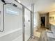 Modern bathroom with a glass-enclosed shower, soaking tub, and wood-look tile flooring at 6947 Cucamelon Ct, Windermere, FL 34786