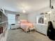 Cozy bedroom with a white bed frame, a decorative chandelier, and ample natural light from the window at 6947 Cucamelon Ct, Windermere, FL 34786