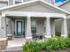 Inviting front porch featuring classic rocking chairs, stone accents, and a neatly landscaped garden area at 6947 Cucamelon Ct, Windermere, FL 34786