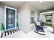 Welcoming front porch with a stylish blue door, striped welcome mat, and decorative potted plants at 6947 Cucamelon Ct, Windermere, FL 34786
