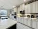 Gourmet kitchen featuring white cabinets, stainless steel appliances, under cabinet lighting, and quartz countertops with backsplash at 6947 Cucamelon Ct, Windermere, FL 34786