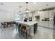 Spacious gourmet kitchen features a large island with seating, pendant lighting, modern appliances, and flows into the dining area at 6947 Cucamelon Ct, Windermere, FL 34786