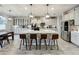 Bright gourmet kitchen features a large center island with seating, pendant lighting, stainless appliances, and plenty of counter space at 6947 Cucamelon Ct, Windermere, FL 34786