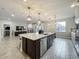 Gourmet kitchen featuring a large center island with seating, pendant lighting, and flows seamlessly into the living room and dining area at 6947 Cucamelon Ct, Windermere, FL 34786