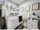 Well-organized laundry room with front-loading washer/dryer, shelving, and charming decor at 6947 Cucamelon Ct, Windermere, FL 34786