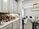 Dry bar with white cabinets and quartz countertops, perfect for entertaining and opens into the living room with a large white sofa at 6947 Cucamelon Ct, Windermere, FL 34786