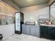 Outdoor kitchen area with a built in grill, beverage fridge and small storage sink at 6947 Cucamelon Ct, Windermere, FL 34786