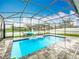 Backyard swimming pool enclosed within a screened in lanai featuring inflatables at 6947 Cucamelon Ct, Windermere, FL 34786