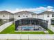 Back of house with a screened in pool area with floats, patio chairs, and nice green grass at 6947 Cucamelon Ct, Windermere, FL 34786