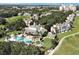 Aerial view of community with pool, bocce ball court, clubhouse, and lush landscaping surrounded by greenery at 7616 Cabana Ct # 301, Reunion, FL 34747