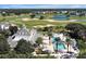 An aerial view shows a clubhouse and a sparkling pool surrounded by lush greenery and tall palm trees at 7616 Cabana Ct # 301, Reunion, FL 34747
