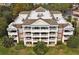 Aerial view of the condo building showcasing balconies, meticulously kept grounds, and outdoor seating areas at 7616 Cabana Ct # 301, Reunion, FL 34747