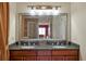 Bathroom featuring double sink vanity with granite countertops and a decorative framed mirror at 7616 Cabana Ct # 301, Reunion, FL 34747