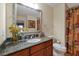 This bathroom has a wooden sink cabinet, a large mirror, and toilet/shower access at 7616 Cabana Ct # 301, Reunion, FL 34747