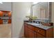 Bathroom vanity featuring a granite countertop and ornate mirror above wood cabinets at 7616 Cabana Ct # 301, Reunion, FL 34747