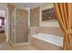 Bright bathroom with a glass-enclosed shower, soaking tub, and stylish tile at 7616 Cabana Ct # 301, Reunion, FL 34747
