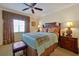 Bedroom with large window, ceiling fan, lamps, nightstand, and a decorative bench seat at 7616 Cabana Ct # 301, Reunion, FL 34747