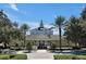 Inviting community clubhouse entrance surrounded by lush landscaping, tall palm trees and manicured shrubbery at 7616 Cabana Ct # 301, Reunion, FL 34747