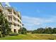 Multi-story building exterior with beautiful landscaping and a golf course view at 7616 Cabana Ct # 301, Reunion, FL 34747
