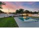 Spacious backyard with a sparkling pool, lush green lawn, and ambient string lights for evening enjoyment at 8120 Gondola Dr, Orlando, FL 32809