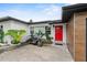 Inviting front entrance with a striking red door and modern landscaping at 8120 Gondola Dr, Orlando, FL 32809