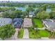 Aerial view of houses with pristine lawns, mature trees, and a lake in the background at 830 Oak St, Orlando, FL 32804