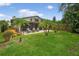 A view of the backyard with a patio seating area, lush lawn, and palm trees offering a relaxing outdoor space at 830 Oak St, Orlando, FL 32804