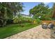 Landscaped backyard with lush greenery, patio area, and mature palm trees offering privacy at 830 Oak St, Orlando, FL 32804