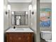 Updated bathroom with stylish vanity, modern lighting, decorative mirror, and calming wall paint at 830 Oak St, Orlando, FL 32804