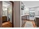 Picture showcasing a bathroom with dark hardwood floors alongside a kitchen with white cabinetry and subway tile backsplash at 830 Oak St, Orlando, FL 32804