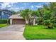 Charming single-story home with a well-manicured lawn and mature tree in front at 830 Oak St, Orlando, FL 32804