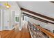 Hallway with hardwood floors, vaulted ceiling with wood beams, and decorative iron railing at 830 Oak St, Orlando, FL 32804