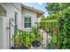 A decorative wrought iron gate leads to a lushly landscaped side yard path at 830 Oak St, Orlando, FL 32804