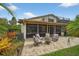 Covered patio features brick flooring, a seating area, and access to upper level deck overlooking backyard at 830 Oak St, Orlando, FL 32804