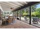 Covered and screened porch with brick flooring, ceiling fan, and outdoor seating area at 830 Oak St, Orlando, FL 32804