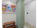 Elegant shower with green tile, a bench, and a view of colorful artwork at 830 Oak St, Orlando, FL 32804