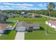 Aerial view of a well-maintained single-Gathering home with a long driveway, green lawn, and mature landscaping at 856 Mendoza Dr, Kissimmee, FL 34758