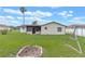 Spacious backyard with lush green grass, fire pit, a screened-in lanai, and wooden swing set at 856 Mendoza Dr, Kissimmee, FL 34758