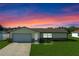 Charming single-story home with a well-maintained lawn and attached two-car garage at dusk at 856 Mendoza Dr, Kissimmee, FL 34758