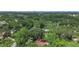 Expansive aerial view showcases a property surrounded by lush, mature trees and the city in the background at 874 Quarters Ct, Port Orange, FL 32129