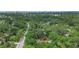 Overhead view displays a home surrounded by dense trees, complemented by views of the city skyline in the distance at 874 Quarters Ct, Port Orange, FL 32129