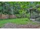 The fenced backyard is surrounded by lush trees and has tropical plants at 874 Quarters Ct, Port Orange, FL 32129
