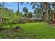 Large backyard featuring a fire pit and mature trees provides a serene outdoor space at 874 Quarters Ct, Port Orange, FL 32129