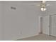 This bedroom features a ceiling fan, tile floors, and a spacious closet with paneled doors at 874 Quarters Ct, Port Orange, FL 32129